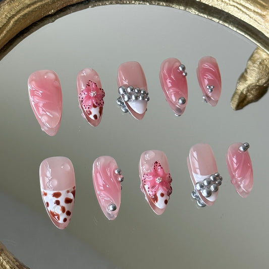 Close-up of the 3D pink sculpted flowers with brown dots and coordinated leopard print accents by MYOB Nails.