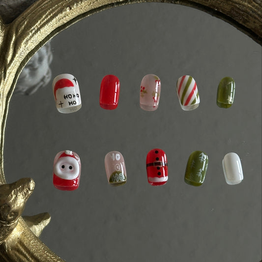 christmas nail with 3d santa and handpainted festival details. featured in green, blue and nude colors.