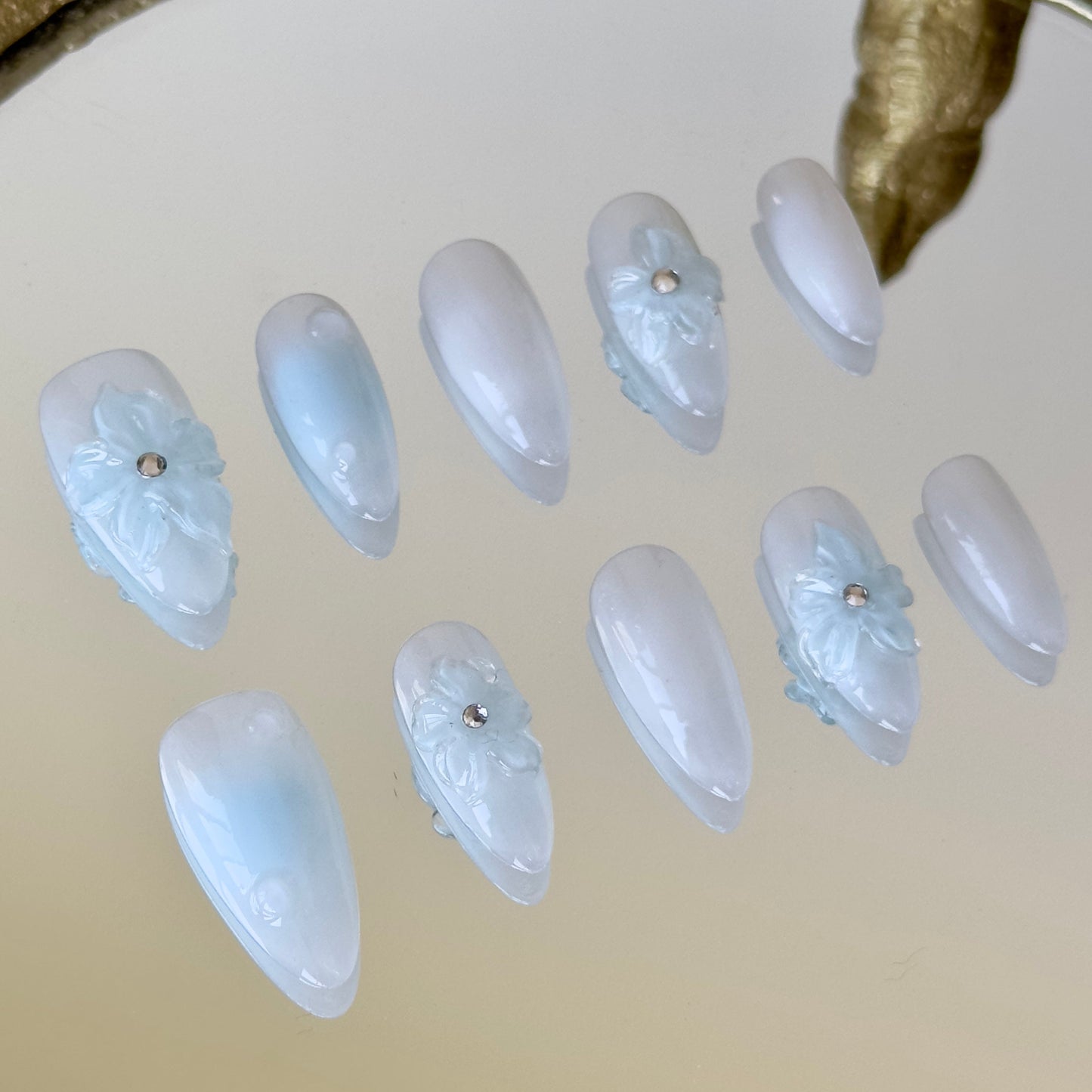 Close-up of 3D water droplets and rhinestone-centered flowers by MYOB Nails.