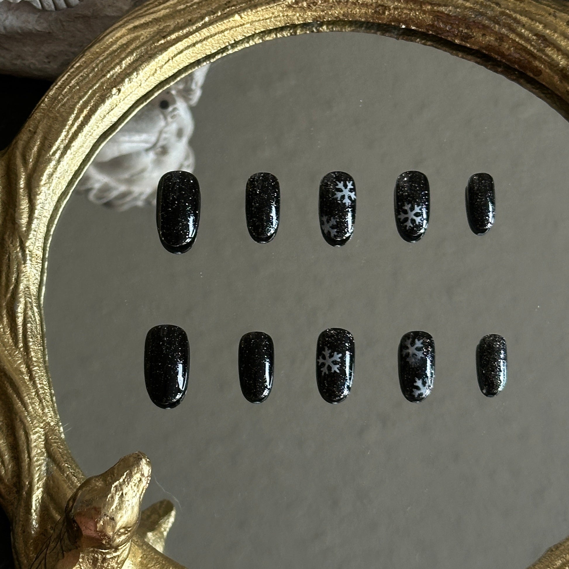 black press-on nails with silver glitter and snowflake