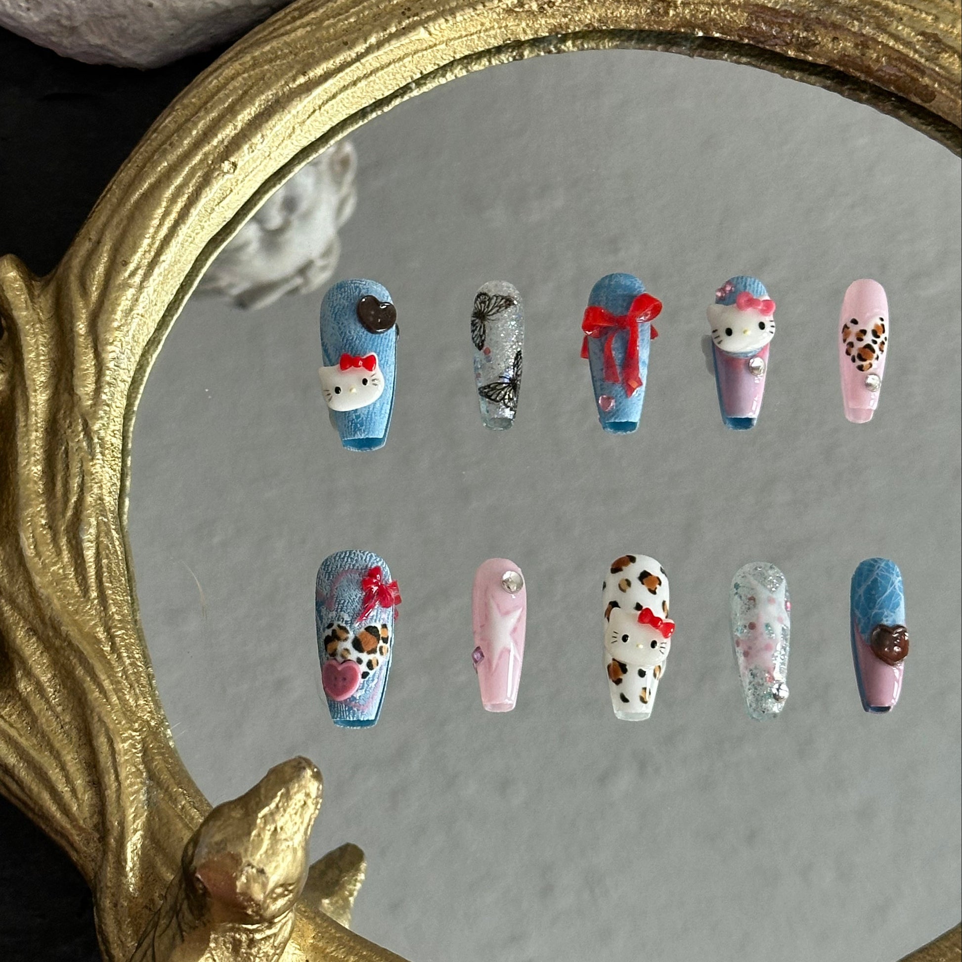 Handmade denim kitty press-on nails with pink, blue, and leopard accents.