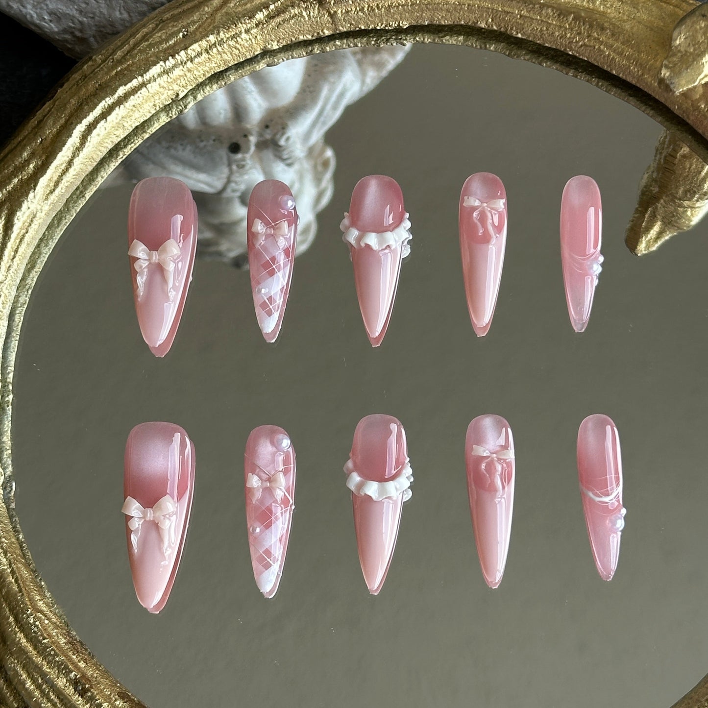 Front view of Ballerina handmade press-on nails by MYOB Nails featuring pink cat-eye base with delicate 3D ribbon bows and pearls.