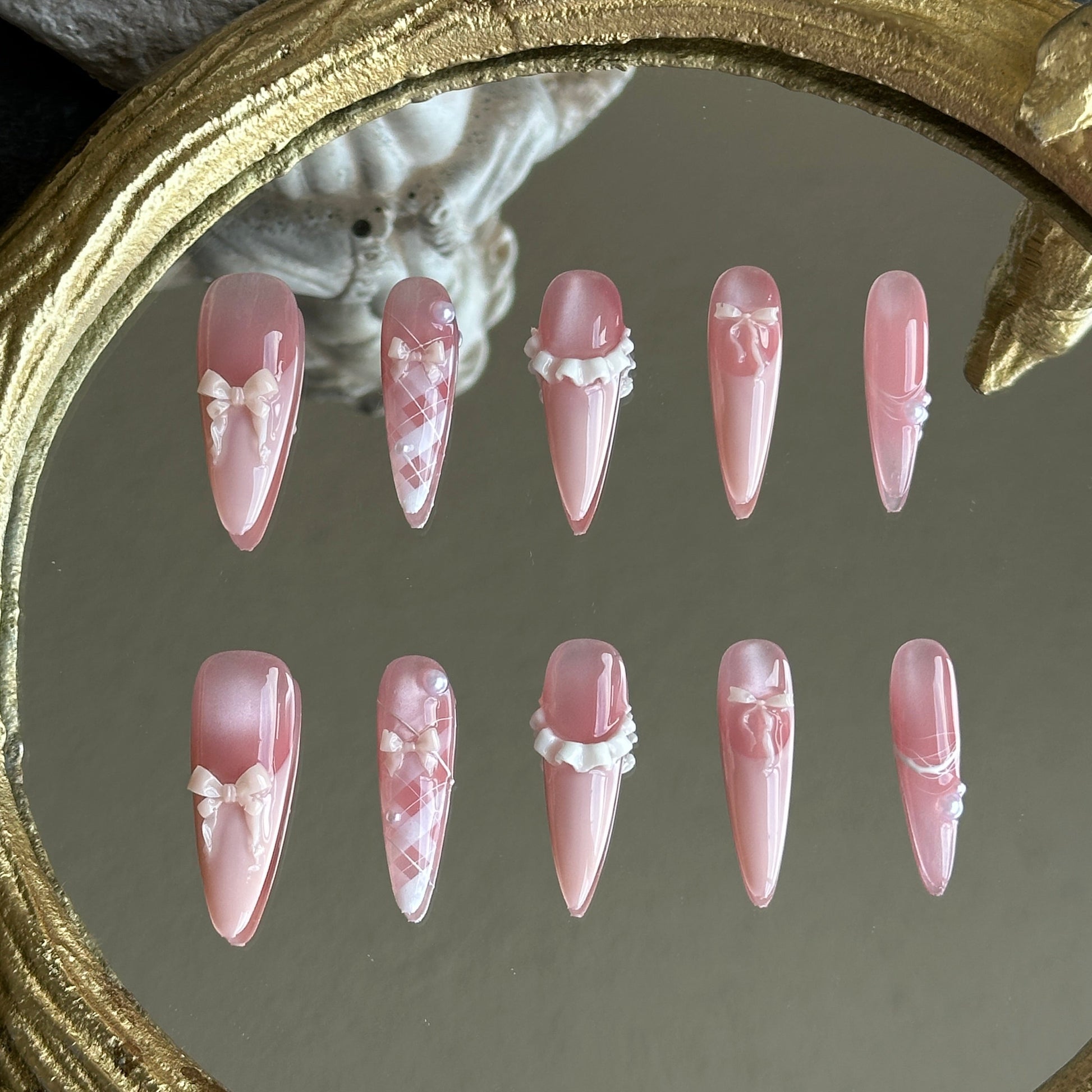 Front view of Ballerina handmade press-on nails by MYOB Nails featuring pink cat-eye base with delicate 3D ribbon bows and pearls.