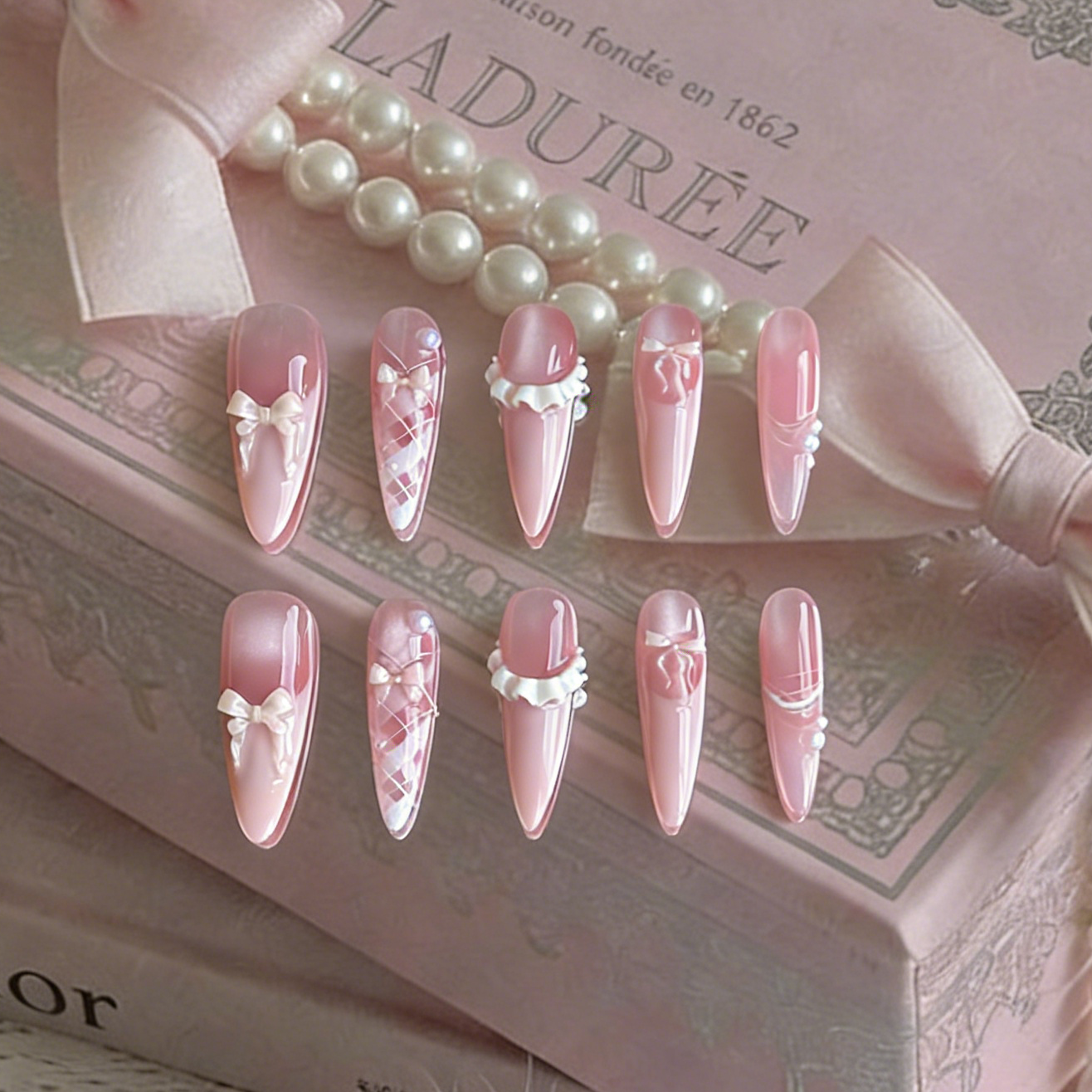 Ballerina press-on nails by MYOB Nails, featuring delicate pink design with bows and pearl-like embellishments.