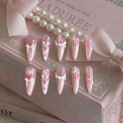 Ballerina press-on nails by MYOB Nails, featuring delicate pink design with bows and pearl-like embellishments.