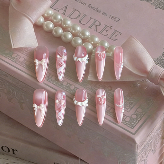 Ballerina press-on nails by MYOB Nails, featuring delicate pink design with bows and pearl-like embellishments.