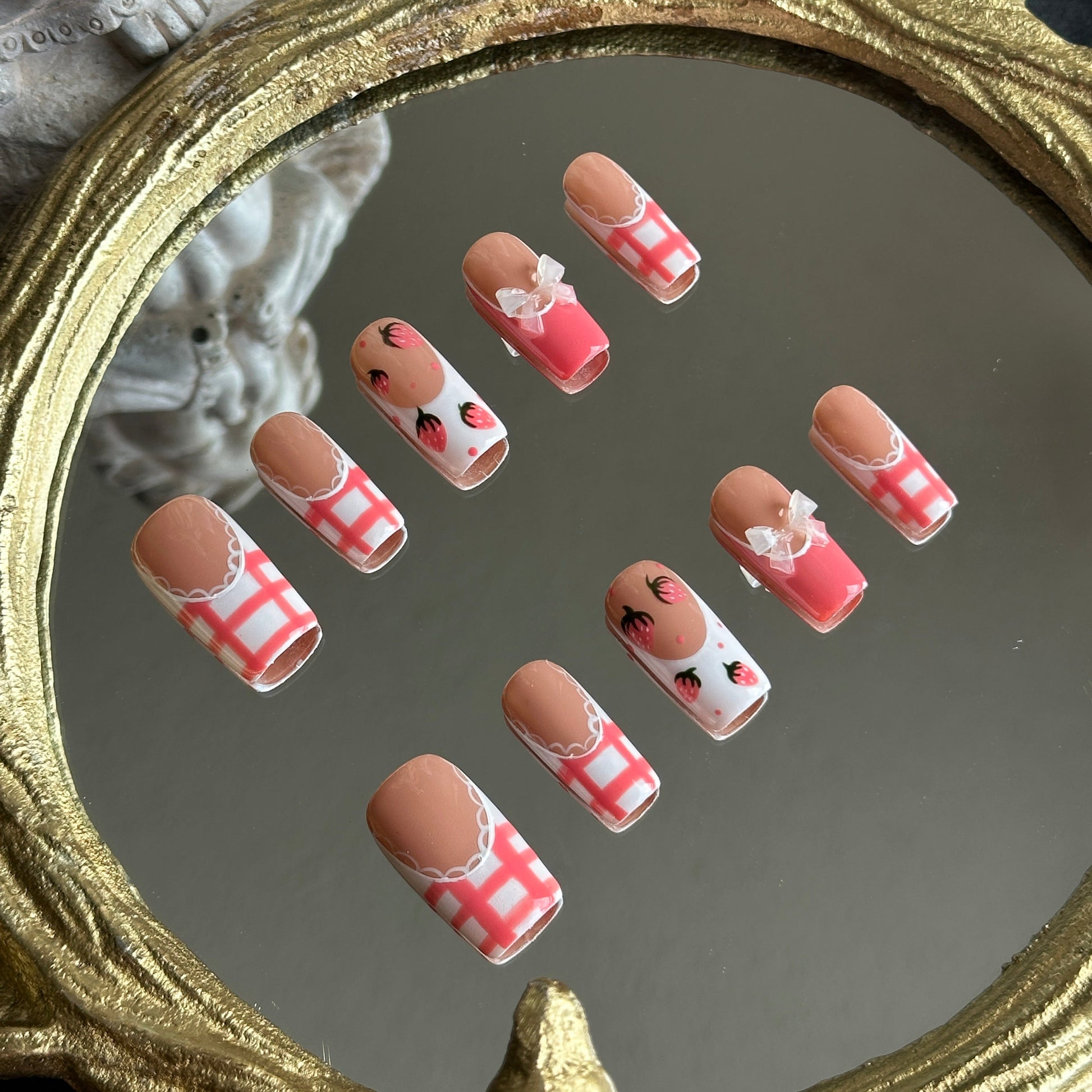 Left side detail of MYOB Nails Berry Gingham set highlighting the delicate hand-painted strawberry motifs and glossy finish.
