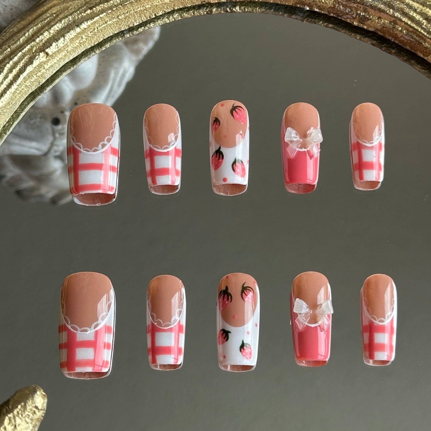 Front view of Berry Gingham handmade press-on nails by MYOB Nails featuring red gingham patterns, hand-painted strawberries, and white lace accents.