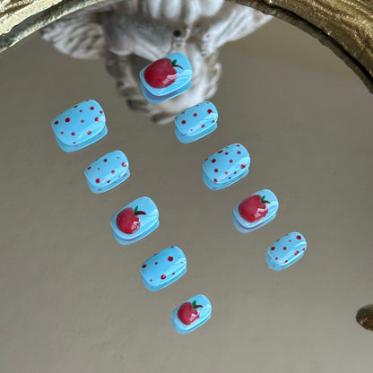Side view highlighting the precise hand-painted red polka dots on the vibrant sky blue nail base.