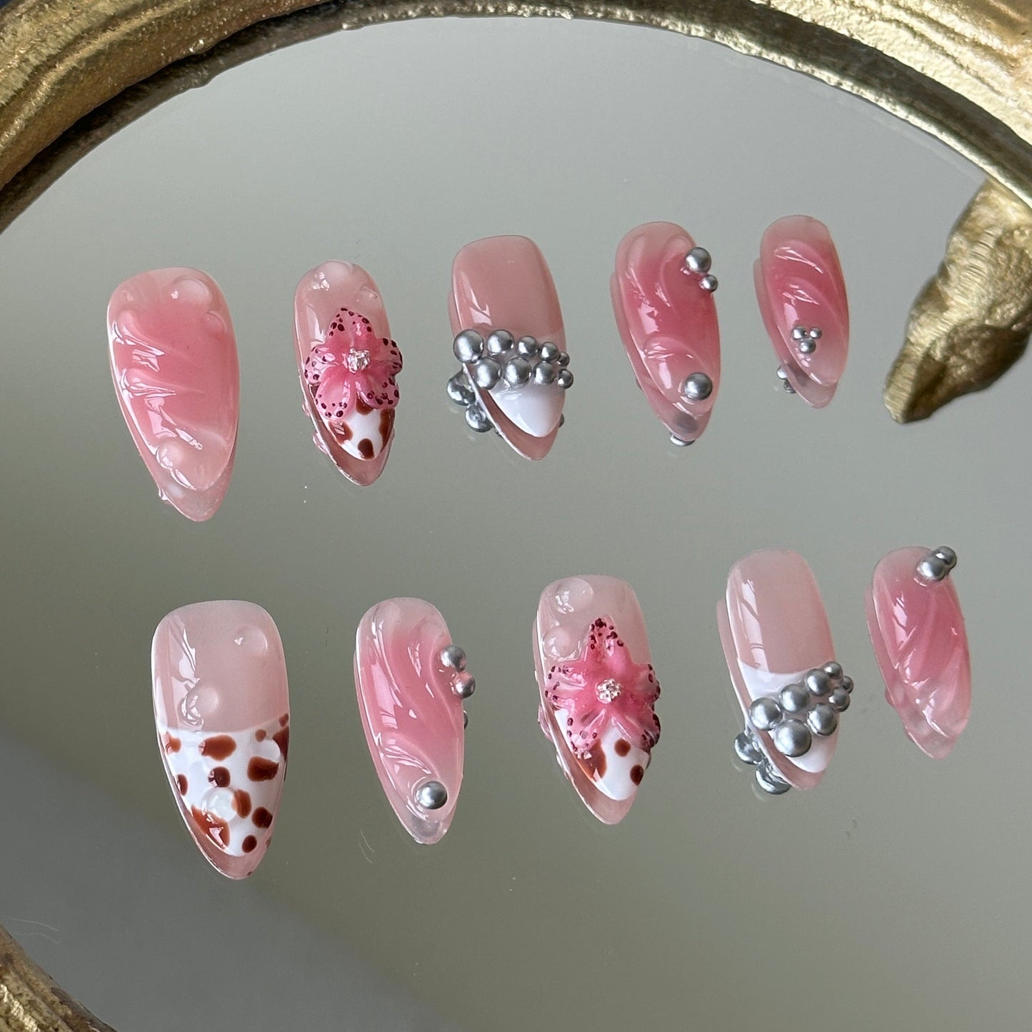Close-up of the 3D pink sculpted flowers with brown dots and coordinated leopard print accents by MYOB Nails.