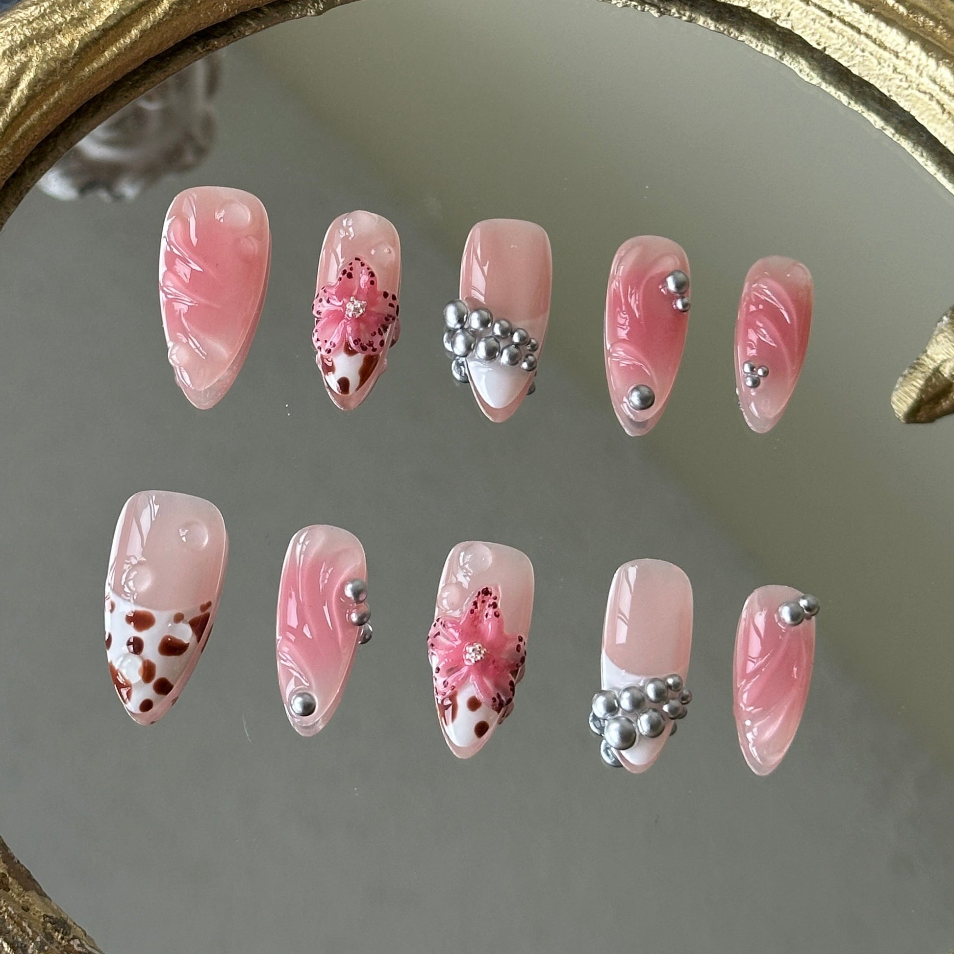Front view of Bloomwild nails showing the nude base, pink blush smudging, and hand-painted leopard French tips.