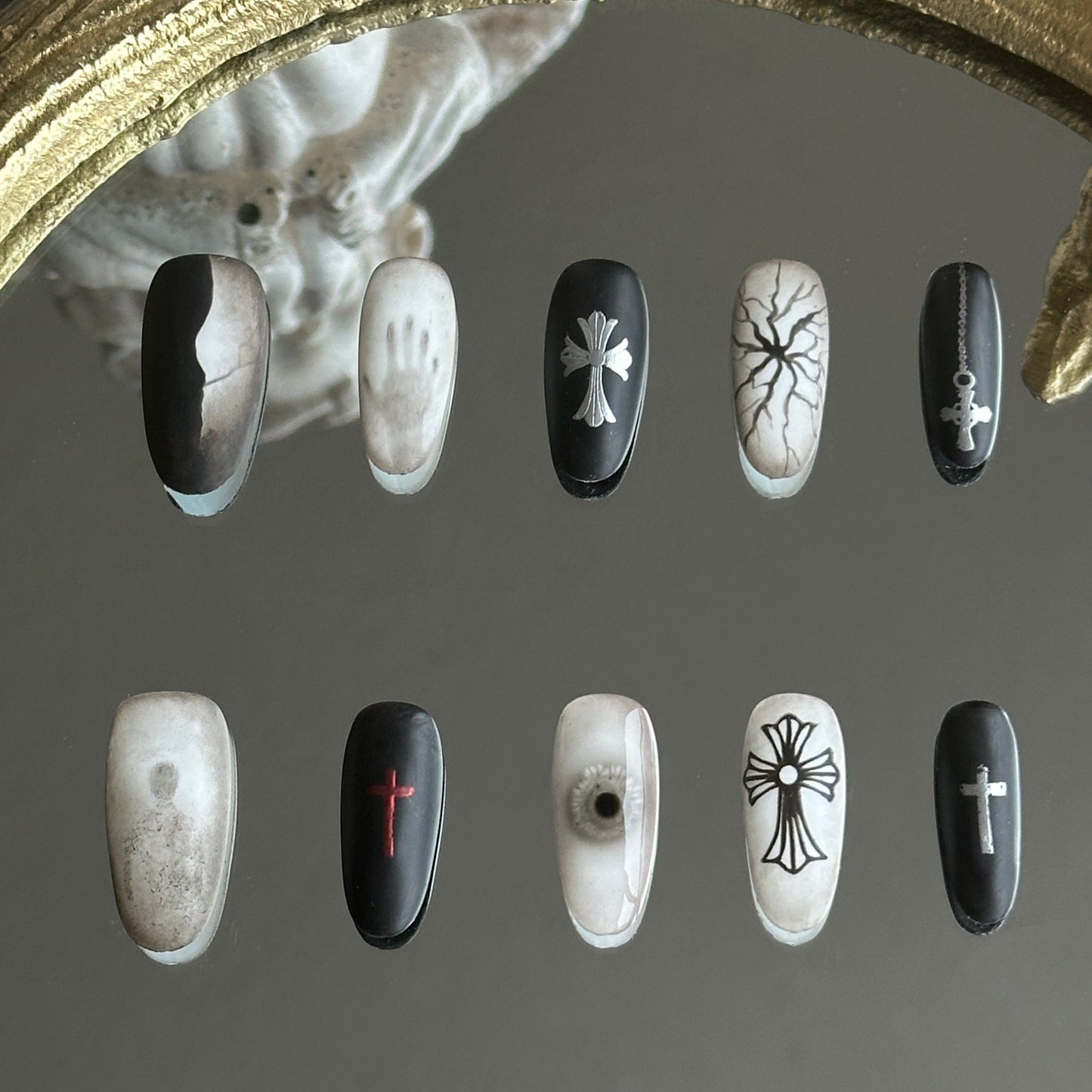 Front view of Blur handmade press-on nails by MYOB Nails featuring black and white horror art with 3D eyes and gothic crosses.