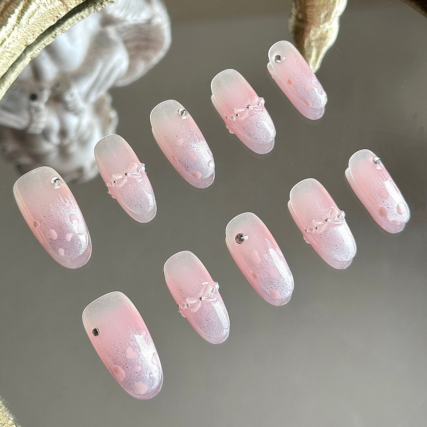 Left side detail of the nail set highlighting the central pink blush gradient and hand-painted pink leopard spots on purple cat-eye.