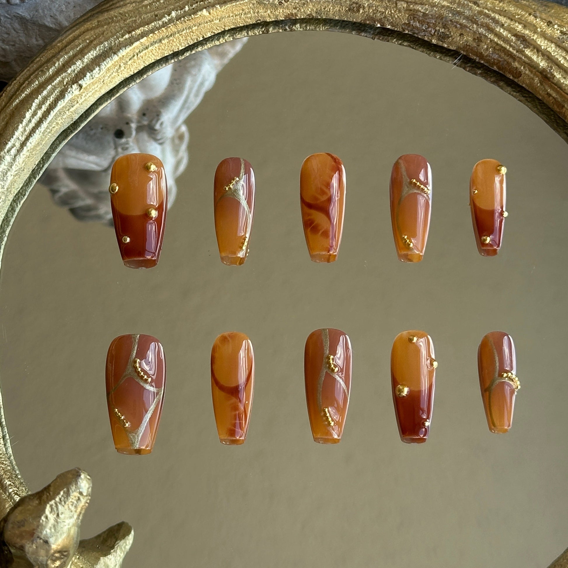 Front view of Caramel Stone handmade press-on nails by MYOB Nails featuring amber marble texture and gold foil accents.