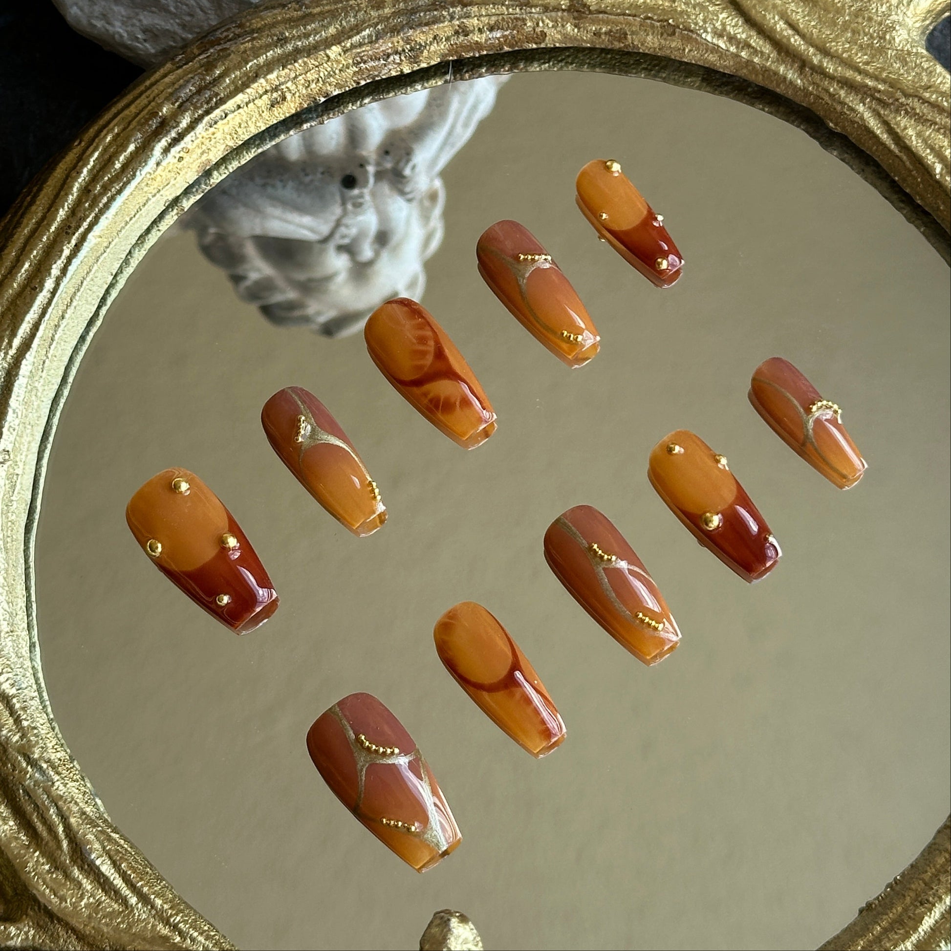 Left side detail of MYOB Nails Caramel Stone set highlighting the deep caramel marble swirl and golden shimmer.