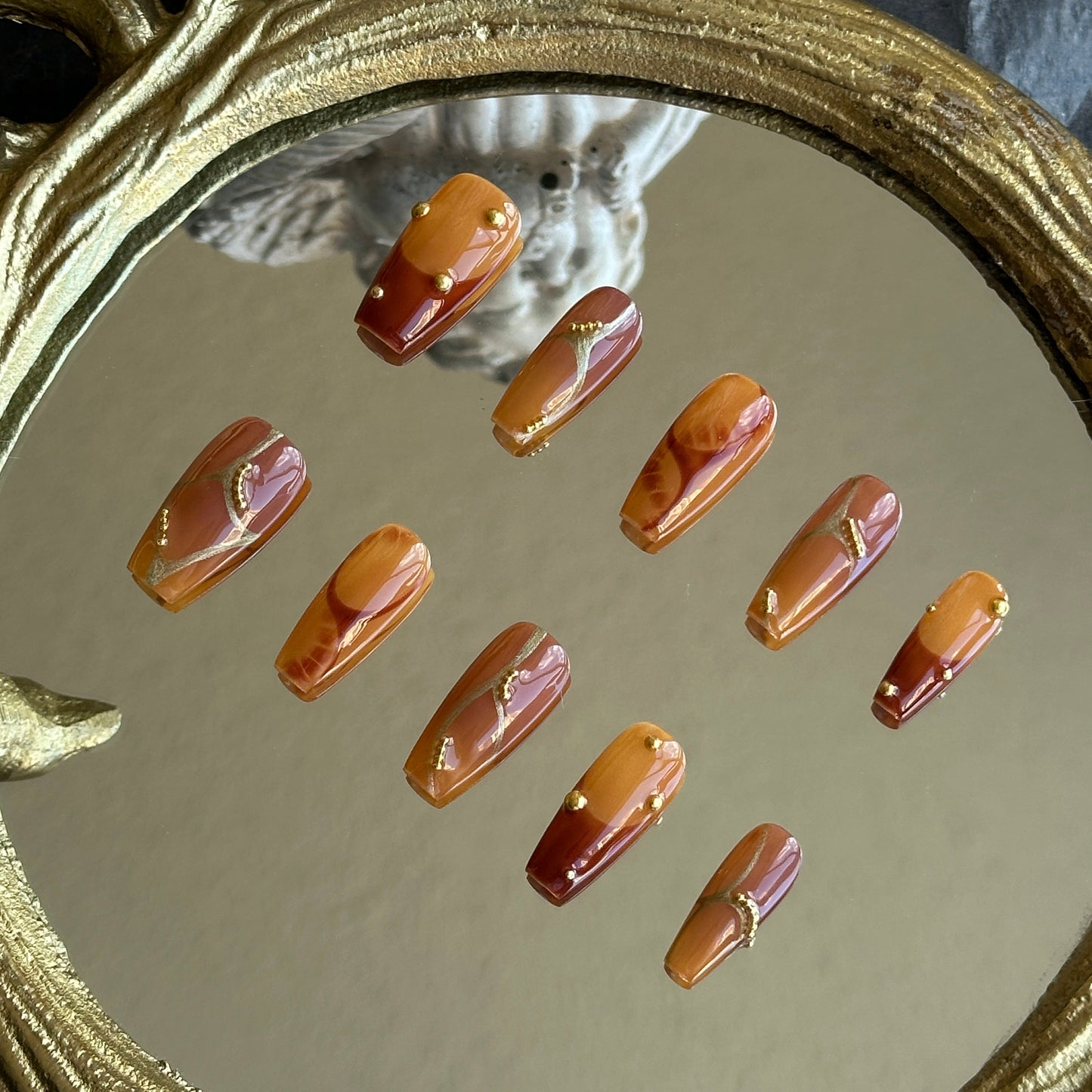 Right side view of Caramel Stone nails by MYOB Nails showing the delicate gold placement on an amber base.