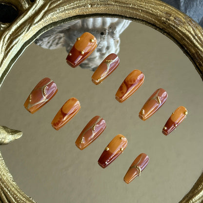 Right side view of Caramel Stone nails by MYOB Nails showing the delicate gold placement on an amber base.