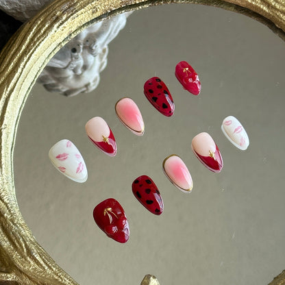 Close-up detail of the sculpted 3D red cherries with metallic gold chrome leaves by MYOB Nails.