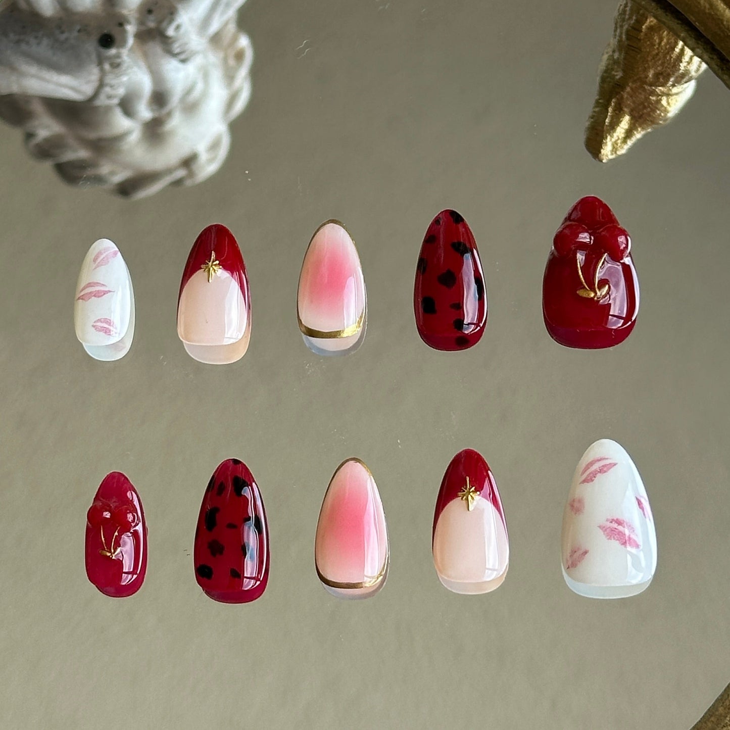 Back view showcasing the irregular gold chrome borders and the soft red blush gradient on the middle finger.