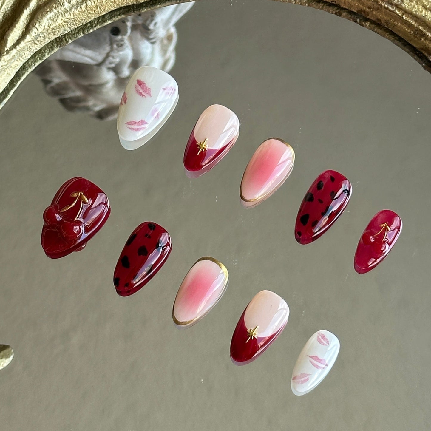 Side view of Cherry Kiss nails highlighting the hand-painted red lip motifs and black feline leopard prints.