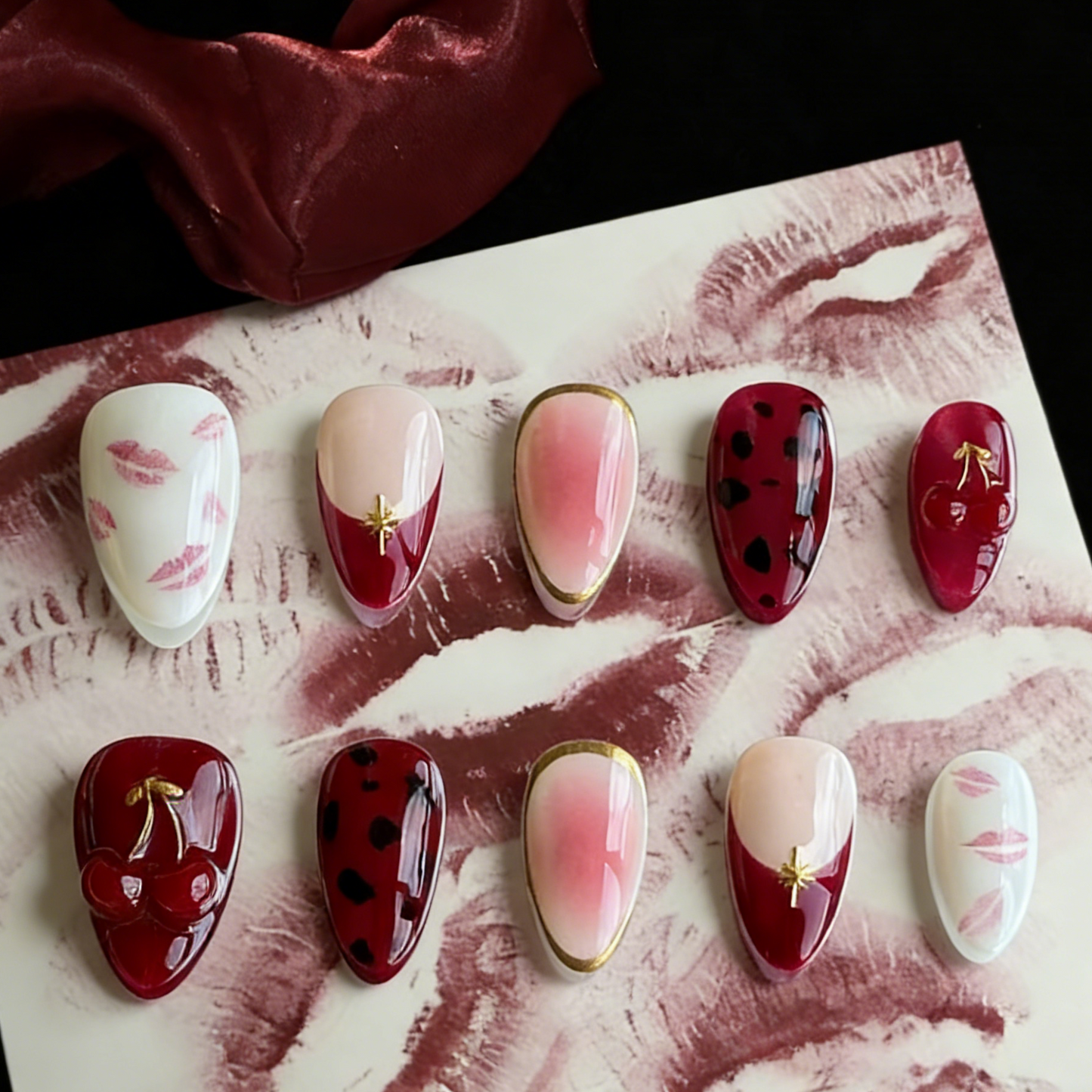 Cherry Kiss press-on nails by MYOB Nails featuring 3D red cherries and gold chrome leaves on a retro-glam background.