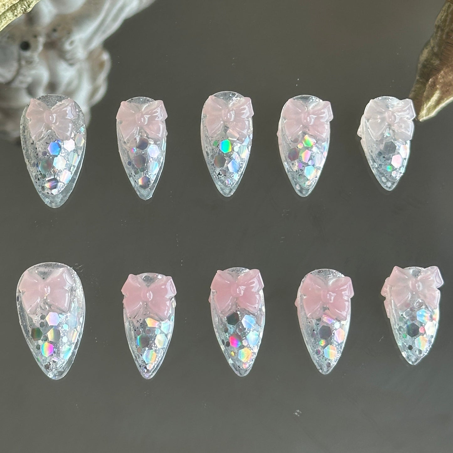 Front view of Crystal Confections handmade nails by MYOB Nails featuring clear bases, laser glitters, and 3D sheer pink bows.