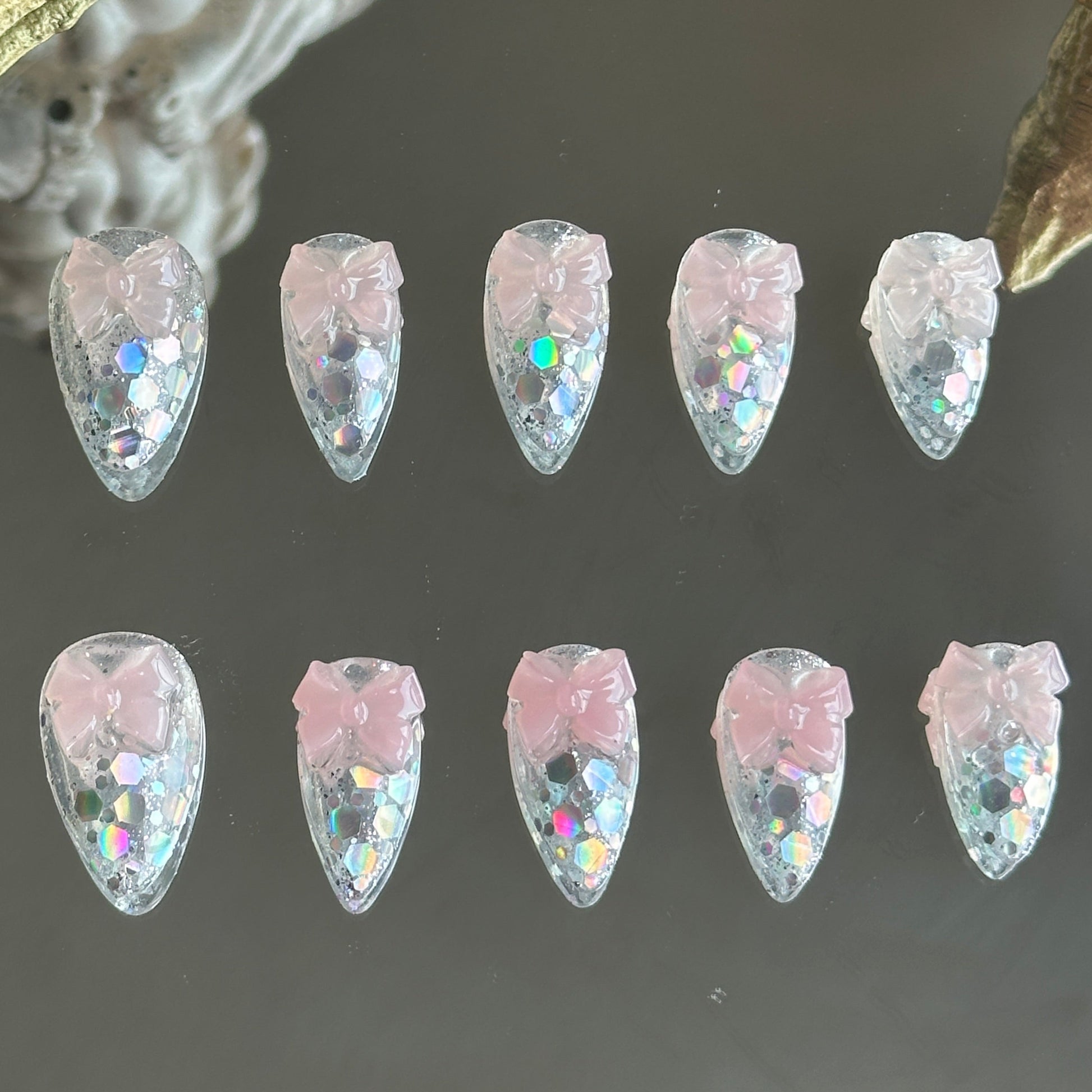 Front view of Crystal Confections handmade nails by MYOB Nails featuring clear bases, laser glitters, and 3D sheer pink bows.