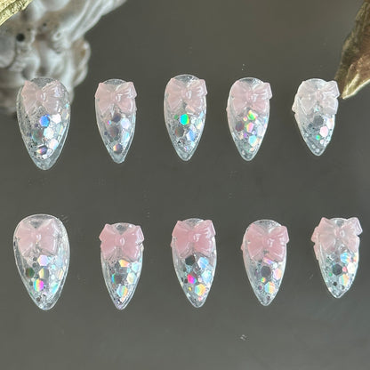 Front view of Crystal Confections handmade nails by MYOB Nails featuring clear bases, laser glitters, and 3D sheer pink bows.