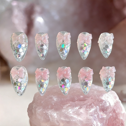Crystal Confections nails by MYOB Nails displayed on raw rose quartz crystals, highlighting the iridescent laser glitters.