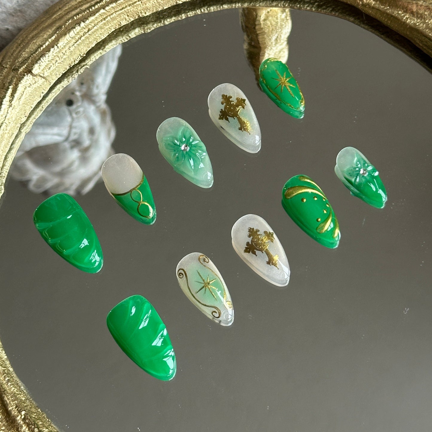 Left side detail of MYOB Nails Emerald Sigil set highlighting the translucent green jade texture and intricate gold sigil motifs.