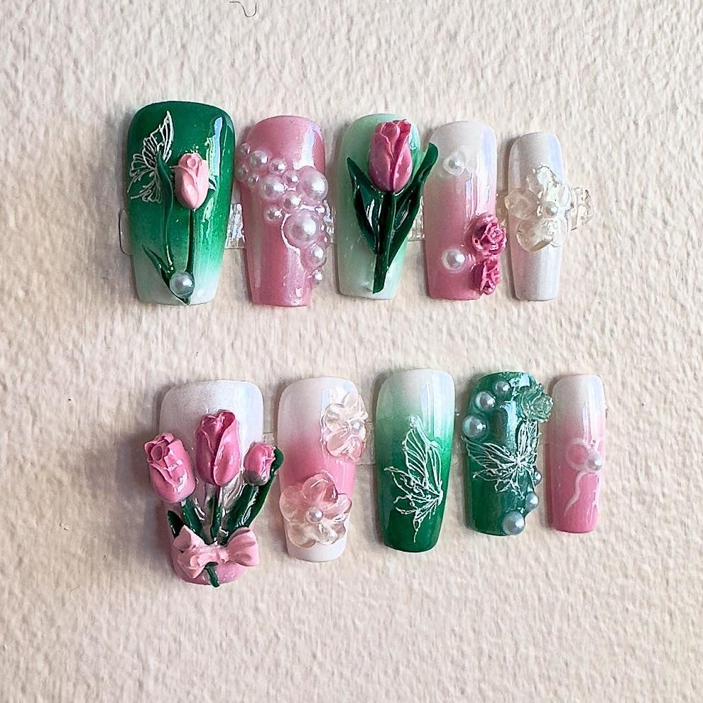 Detailed shot of handcrafted 3D tulips and a cluster of elegant pearls on a pink shimmering base.