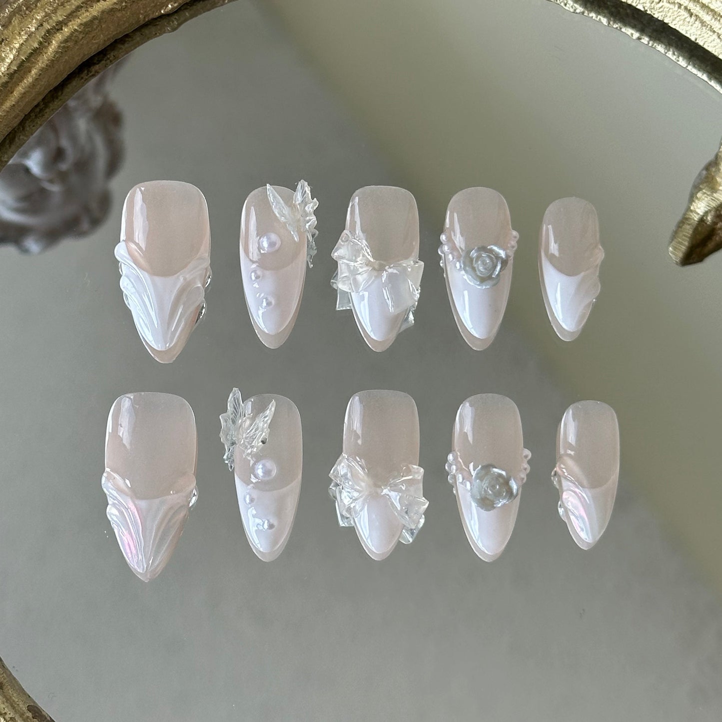 Front view of Fairy Bride handmade nails showing the sheer nude base with white French tips and pearl accents.