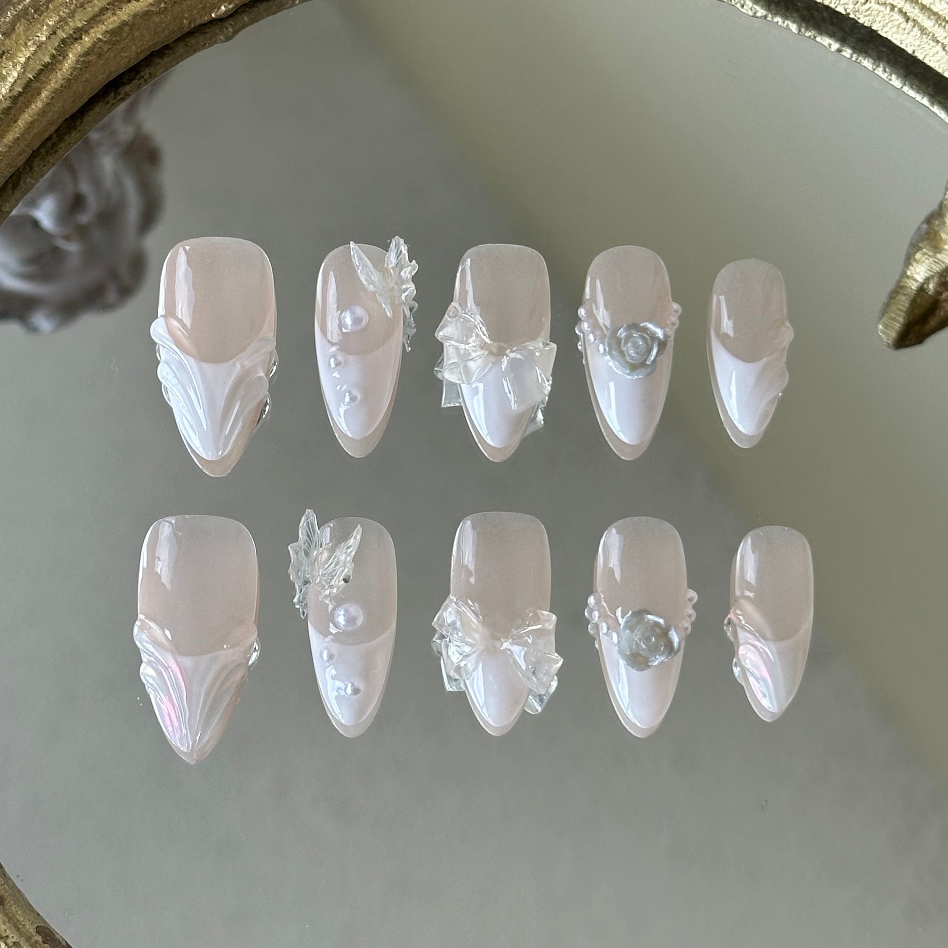 Front view of Fairy Bride handmade nails showing the sheer nude base with white French tips and pearl accents.