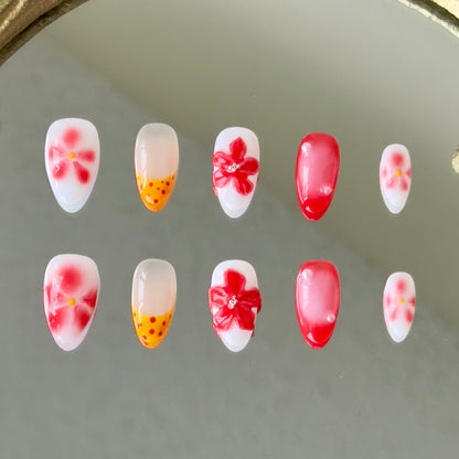 Front view of Flamekissed nails showing the red ombre, yellow French tips, and delicate hand-painted details.