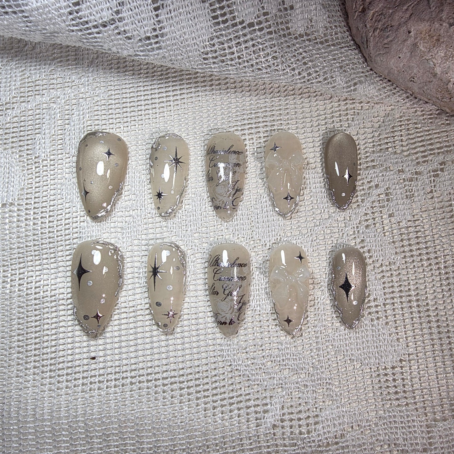 A complete overhead view of the Galactic Poetry set, showing the balanced celestial art on a shimmering beige cat-eye base.