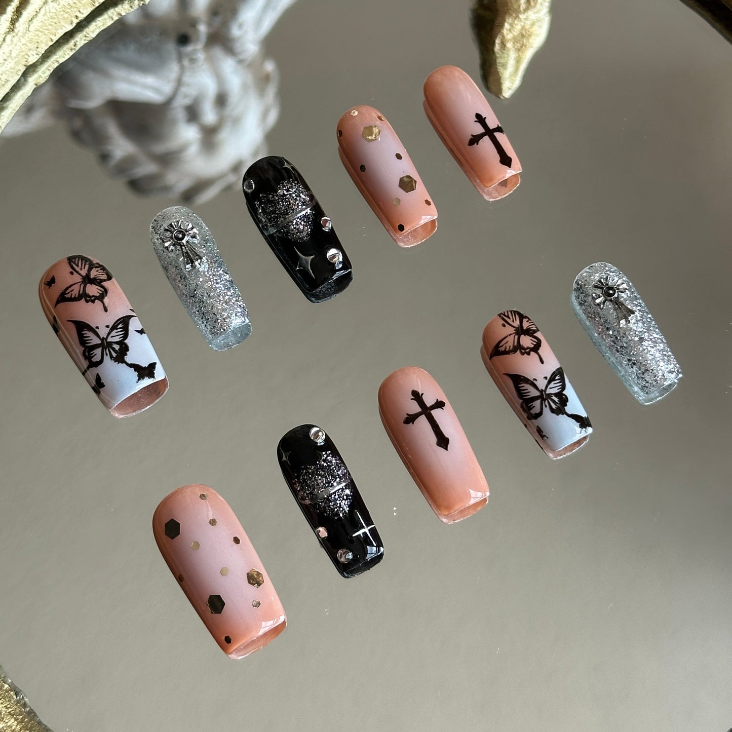 Left side detail of MYOB Nails Gothic Flutter set highlighting the sharp, hand-painted black butterfly wings on a soft pink base.