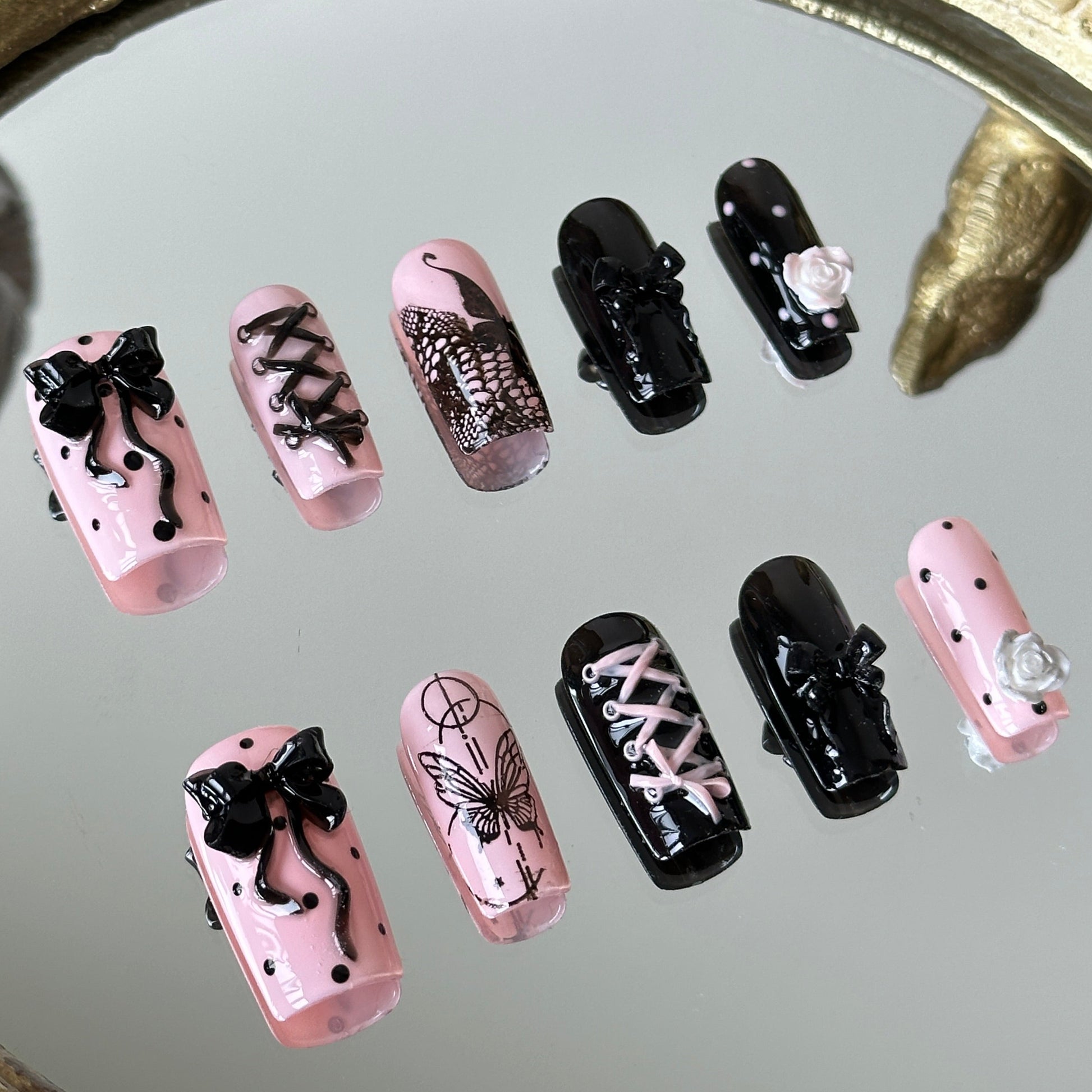 Close-up of the 3D sculpted roses and intricate black corset-style ribbon lacing by MYOB Nails.