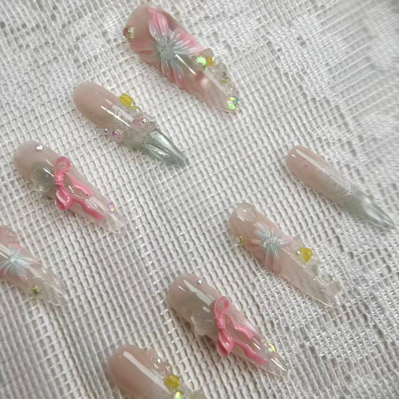 Macro shot of A Letter from Spring press-on nails, highlighting the delicate 3D butterfly layers and the sparkling depth of the pink and green cat-eye base.