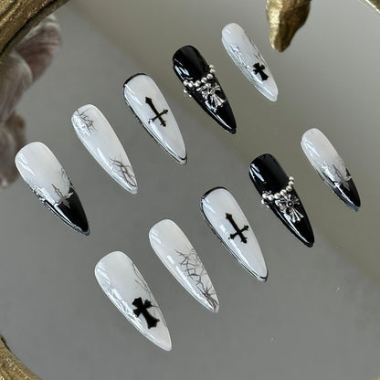 Close-up of the 3D metallic cross and silver steel beads on the ring-finger nail by MYOB Nails.