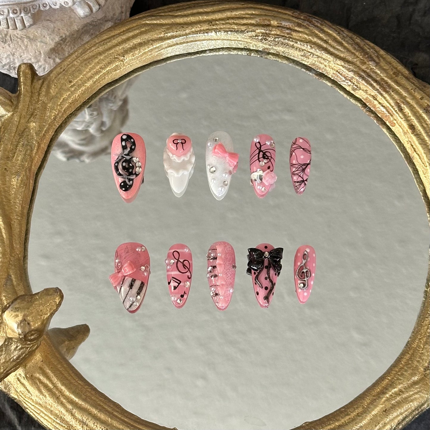 Front view of Melody Muse nails showing hand-painted piano keys, musical staffs, and sparkling rhinestone accents.