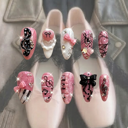Melody Muse press-on nails by MYOB Nails featuring pink glitter bases, 3D black musical notes, and delicate pink bows.