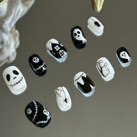 Left side detail of MYOB Nails Midnight Masquerade set highlighting the expressive hand-painted skeleton and pumpkin character faces.