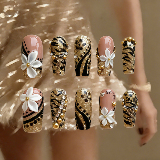 Millennium Disco press-on nails by MYOB Nails featuring gold glitter, hand-painted leopard and tiger prints, and 3D white flowers.