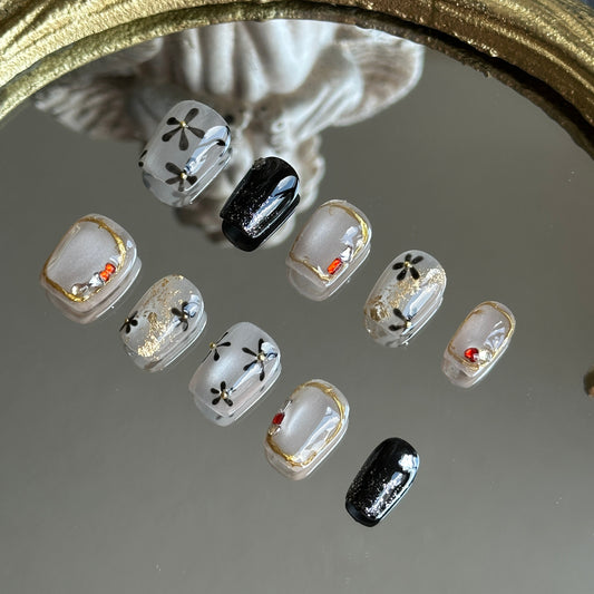 Right side view of Moonlit Blossom nails by MYOB Nails showcasing irregular gold chrome frames with red and silver rhinestones.