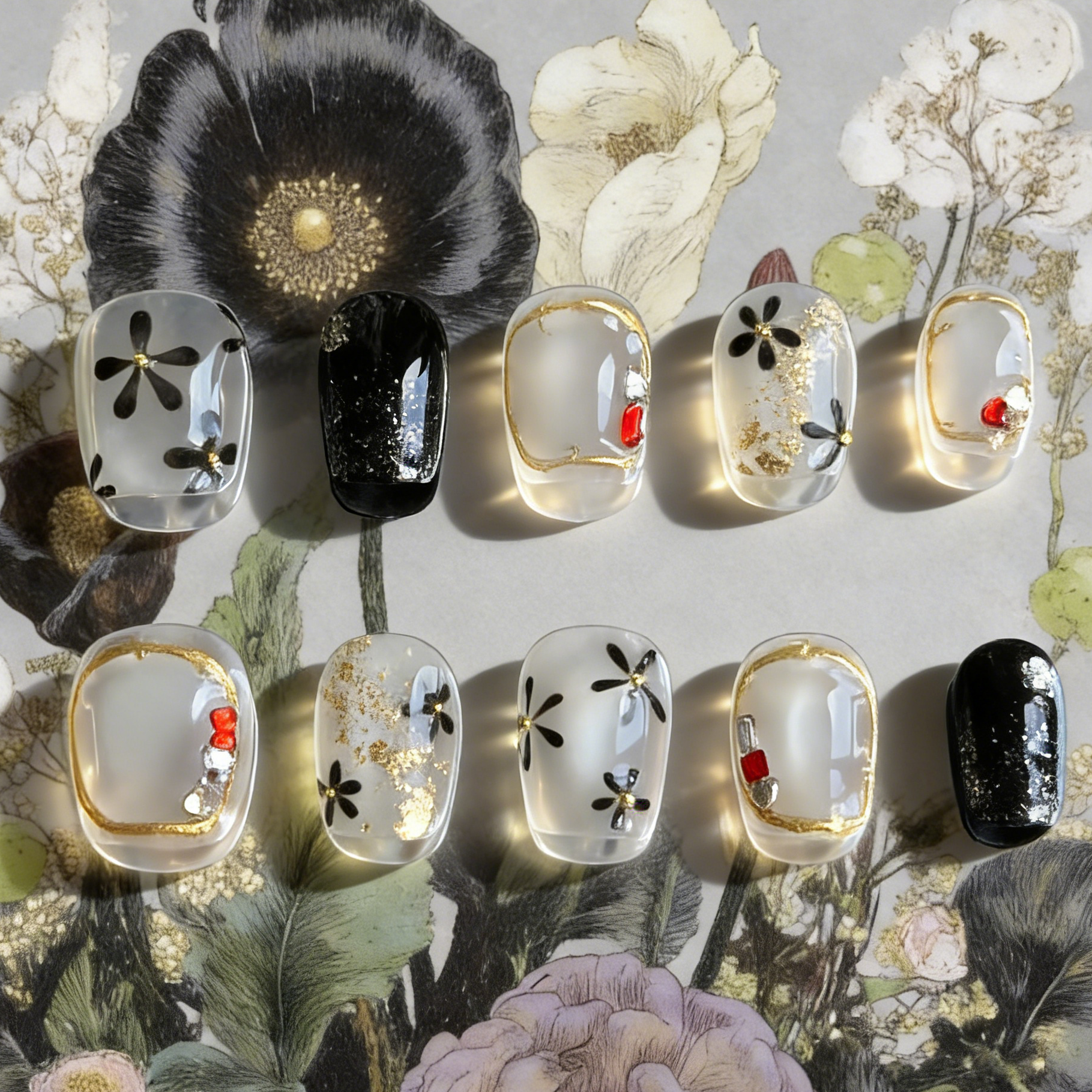 Moonlit Blossom nails by MYOB Nails featuring silver cat-eye bases with hand-painted black flowers and gold chrome frames.