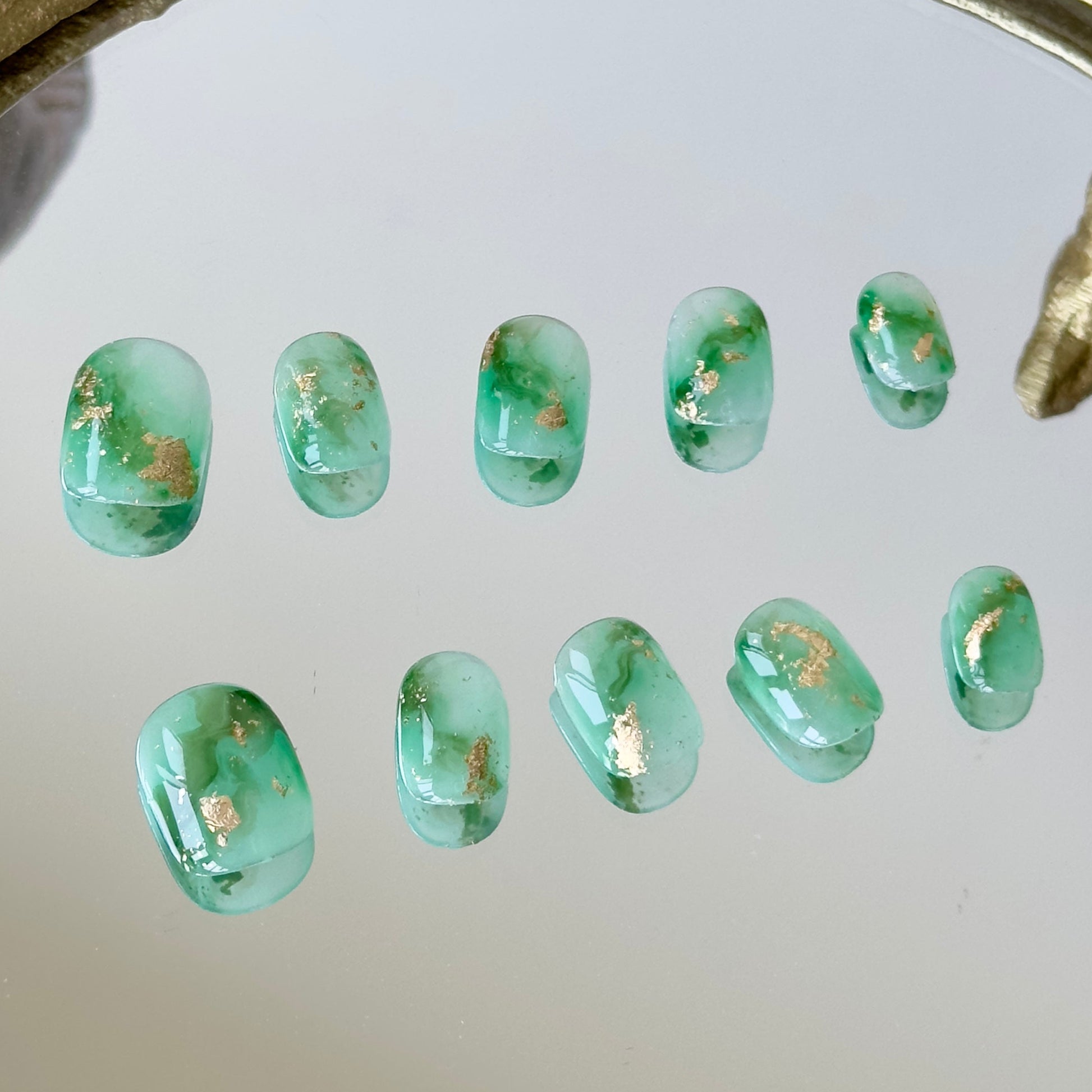 Close-up of the intricate green marble smudge effect inspired by forest moss by MYOB Nails.