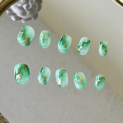 Front view of Mossy nails showing the natural diagonal green marbling and luxury gold foil accents.