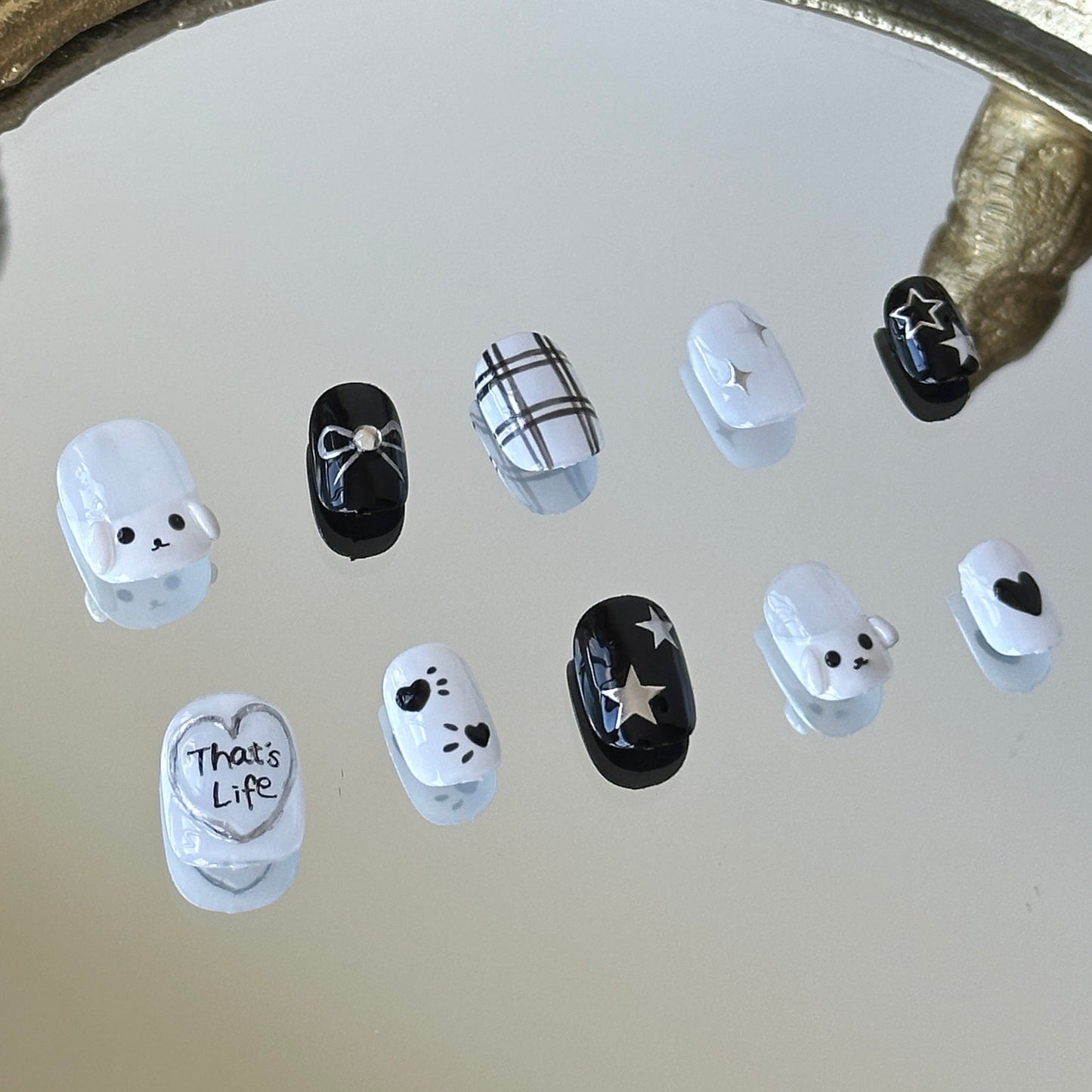 Close-up of the left side of MYOB Nails press-on set, highlighting the 3D white dog charm and hand-painted black and white plaid patterns