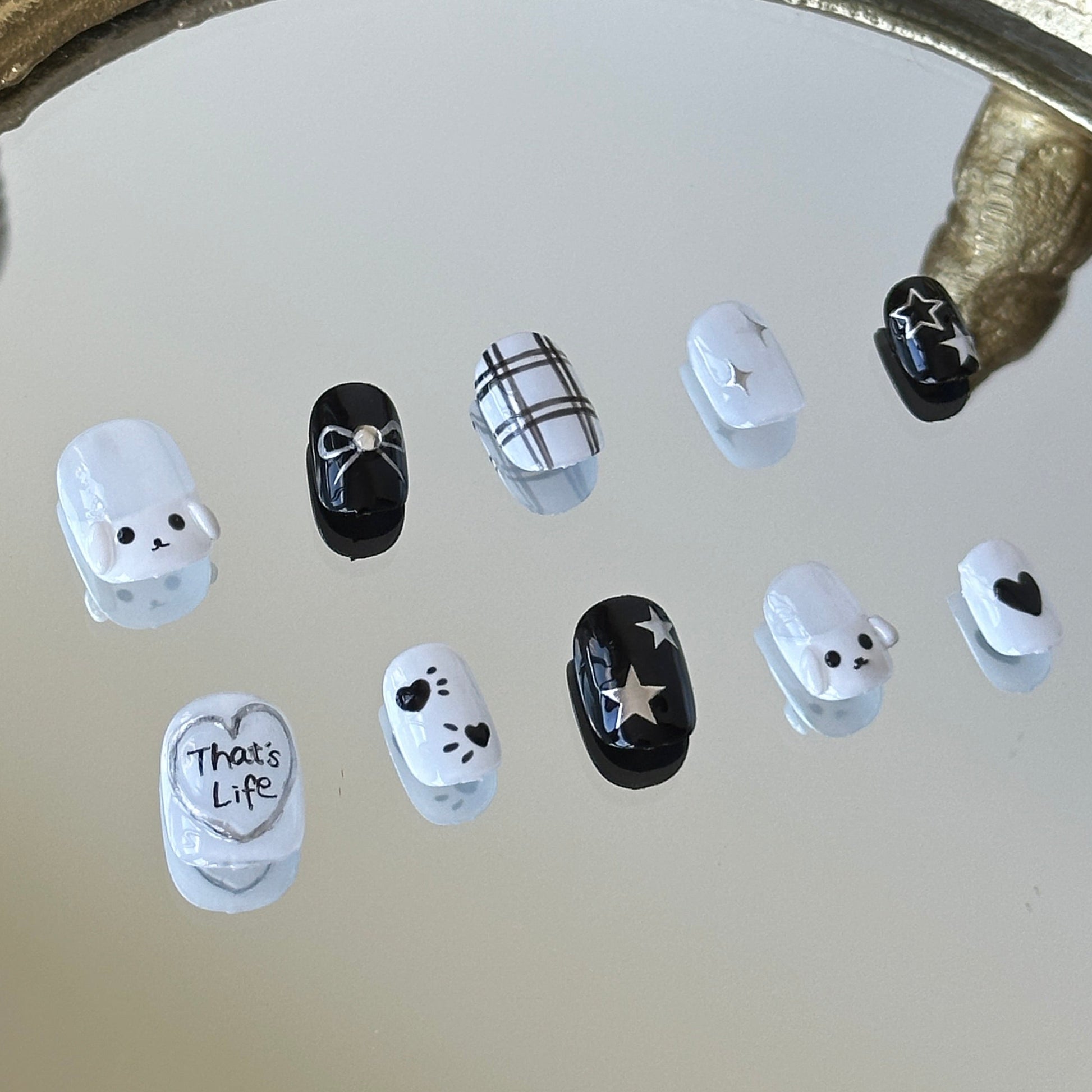 Close-up of the left side of MYOB Nails press-on set, highlighting the 3D white dog charm and hand-painted black and white plaid patterns