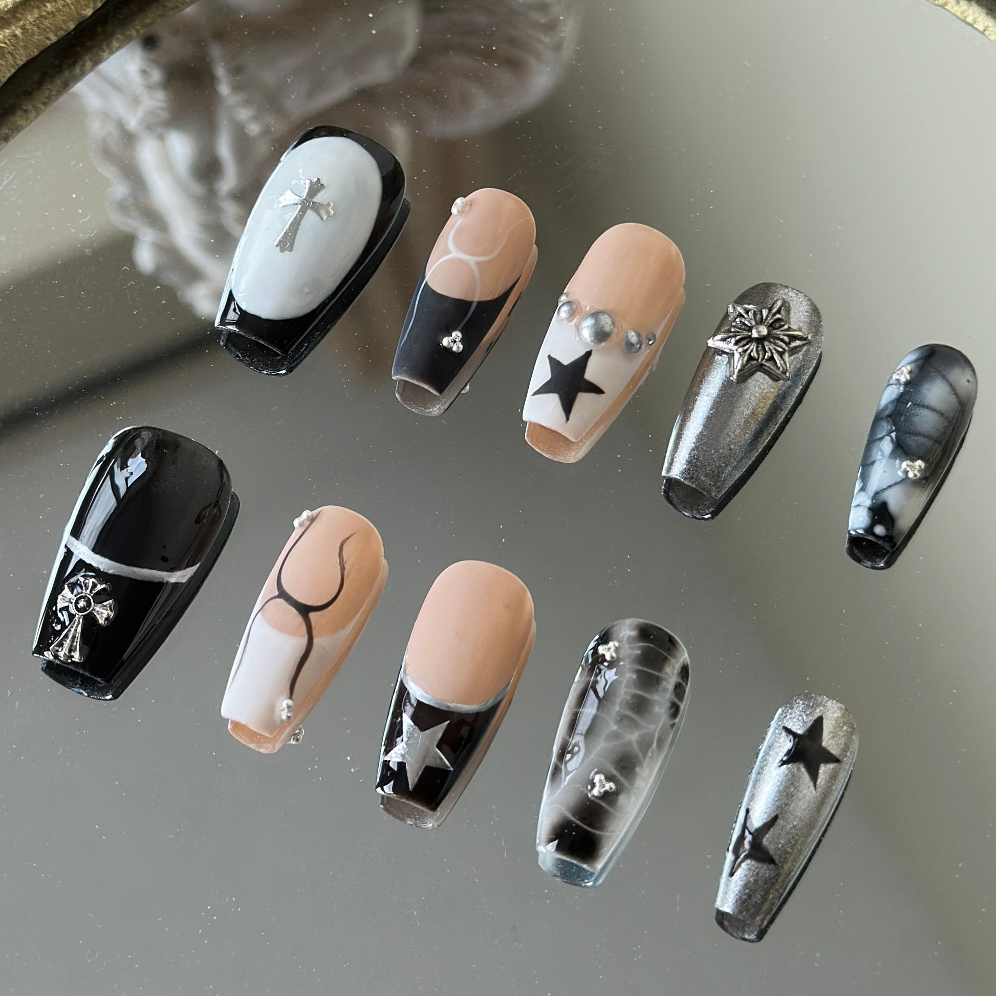 Right side view of Crux nails by MYOB Nails, showcasing bold black star motifs, silver micro-studs, and a sleek matte-meets-glossy finish